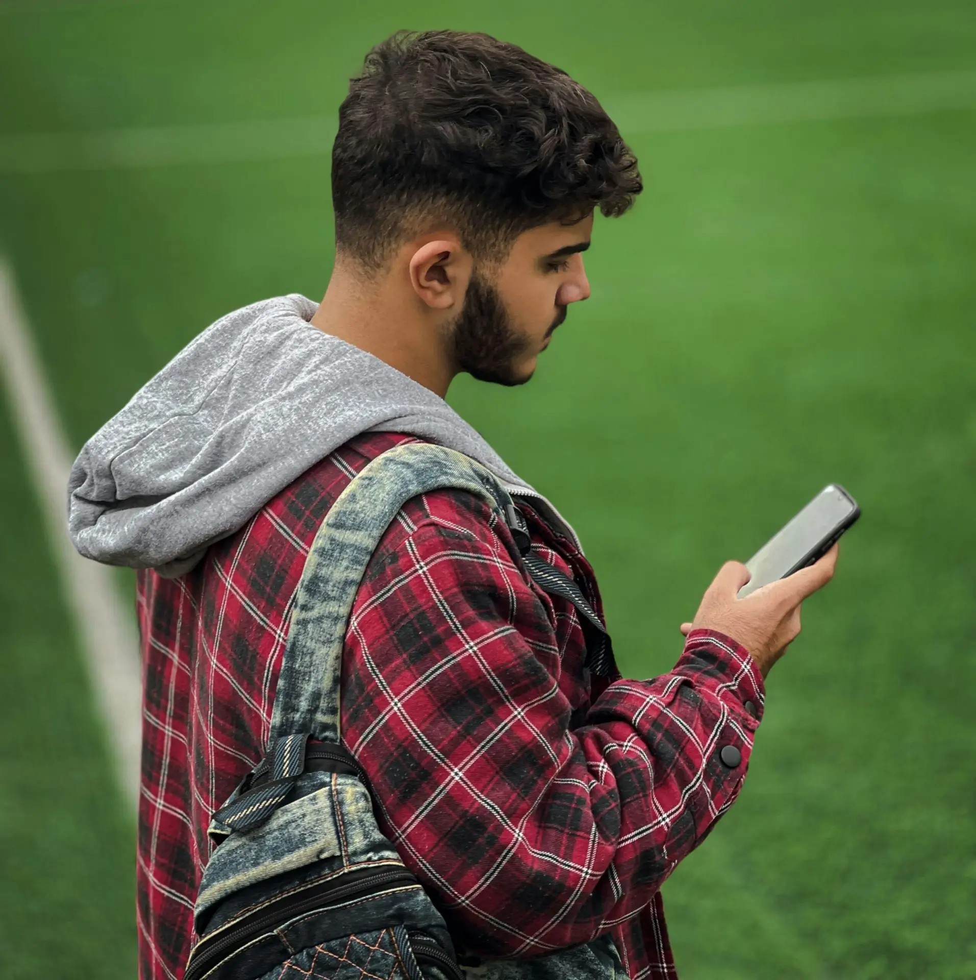 Estudante universitário consultando pelo celular informações sobre auxílio moradia FUMP perto da UFMG